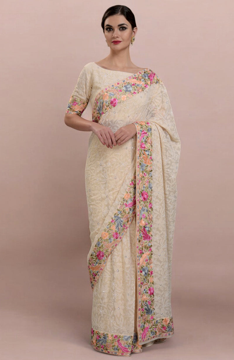 A woman models a champagne Lucknowi Chikankari and Parsi Gara hand-embroidered saree.