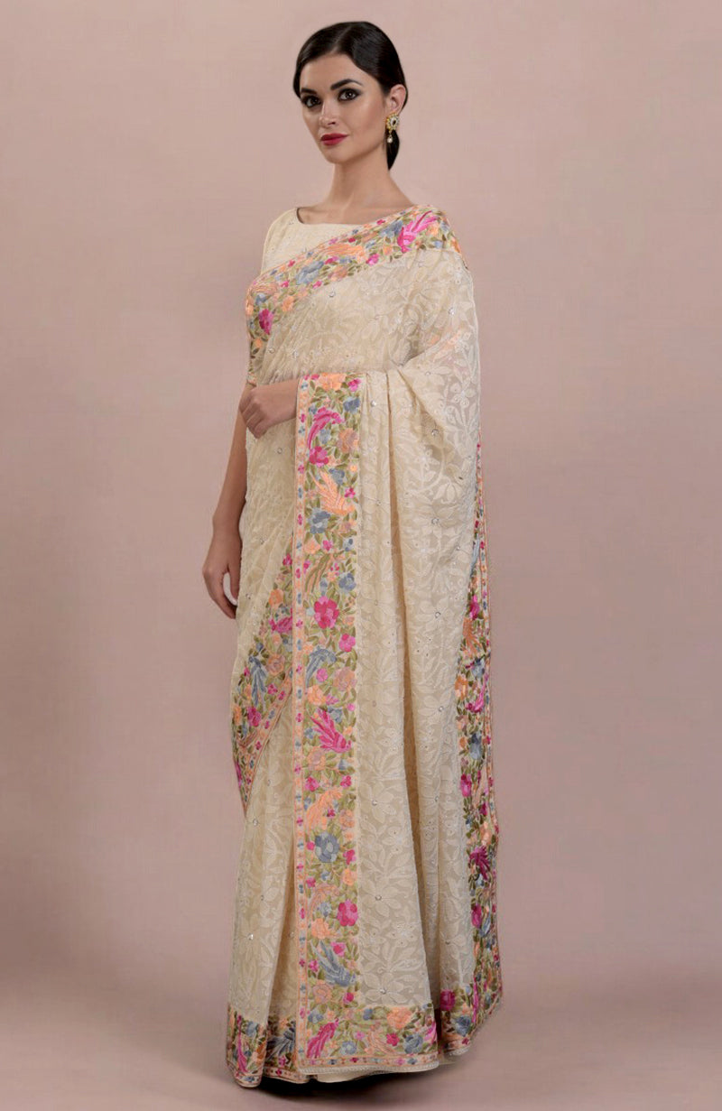 Woman in a champagne Lucknowi Chikankari and Parsi Gara hand-embroidered saree.
