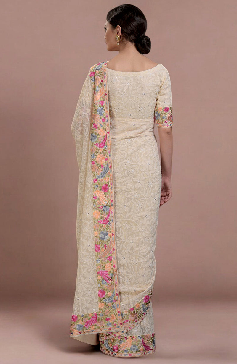 A woman from behind wearing a champagne chikankari and Parsi Gara embroidered saree.