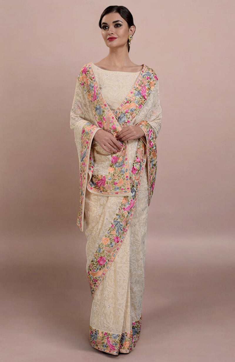 A woman models a champagne Lucknowi Chikankari and Parsi Gara hand-embroidered saree.