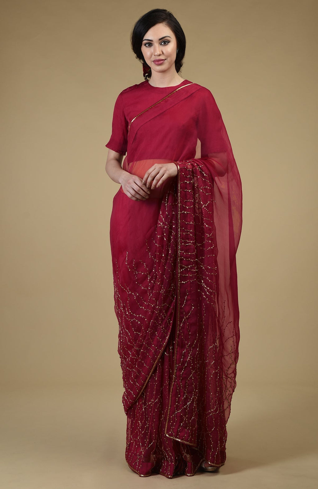 A woman models a red-gold beaded and sequin zardozi hand-embroidered saree.