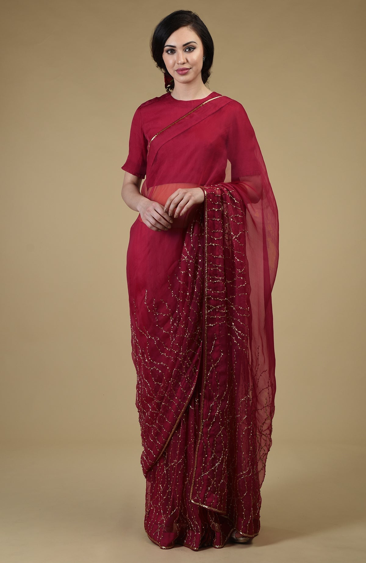 A woman models a red-gold beaded and sequin zardozi hand-embroidered saree.