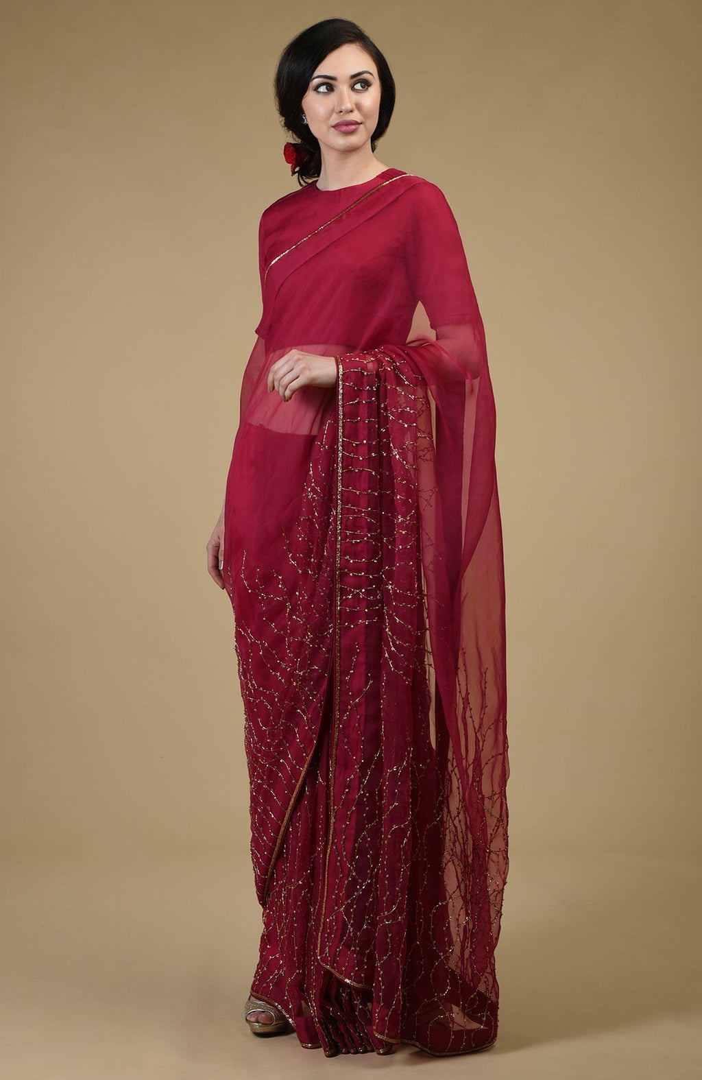 A woman models a classic red-gold beads and sequin zardozi hand-embroidered saree.