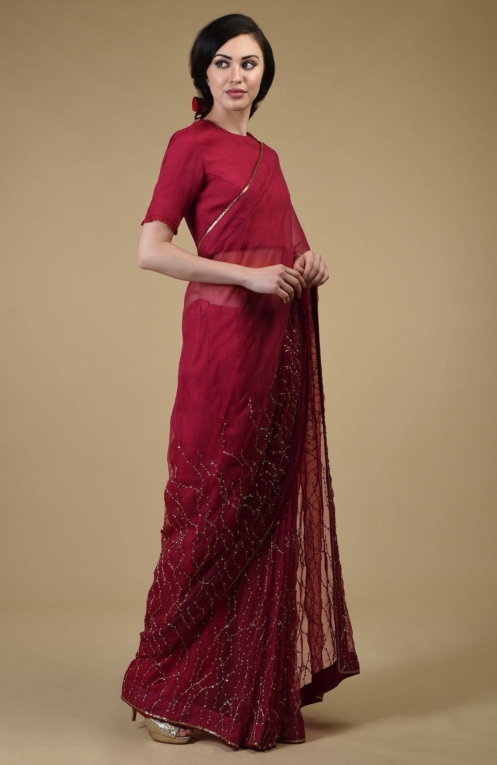 A woman models a red-gold beaded and sequin zardozi hand-embroidered saree.
