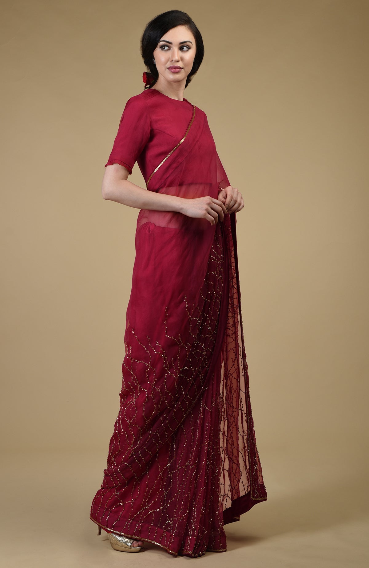 A woman models a red-gold beaded and sequin zardozi hand-embroidered saree.