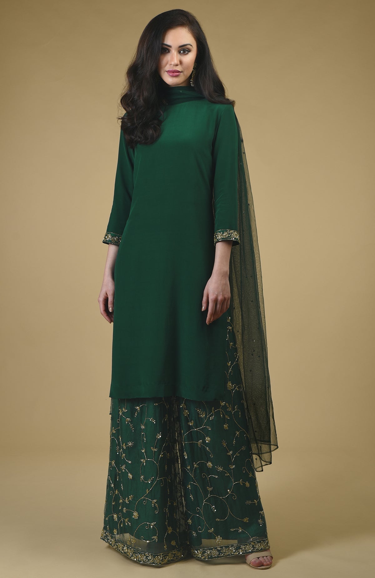 An emerald green sharara suit with gold bead and sequin embroidery.