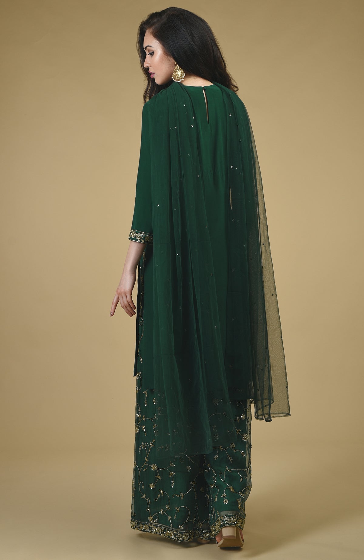 Emerald green sharara suit with gold embroidery and a sheer dupatta.