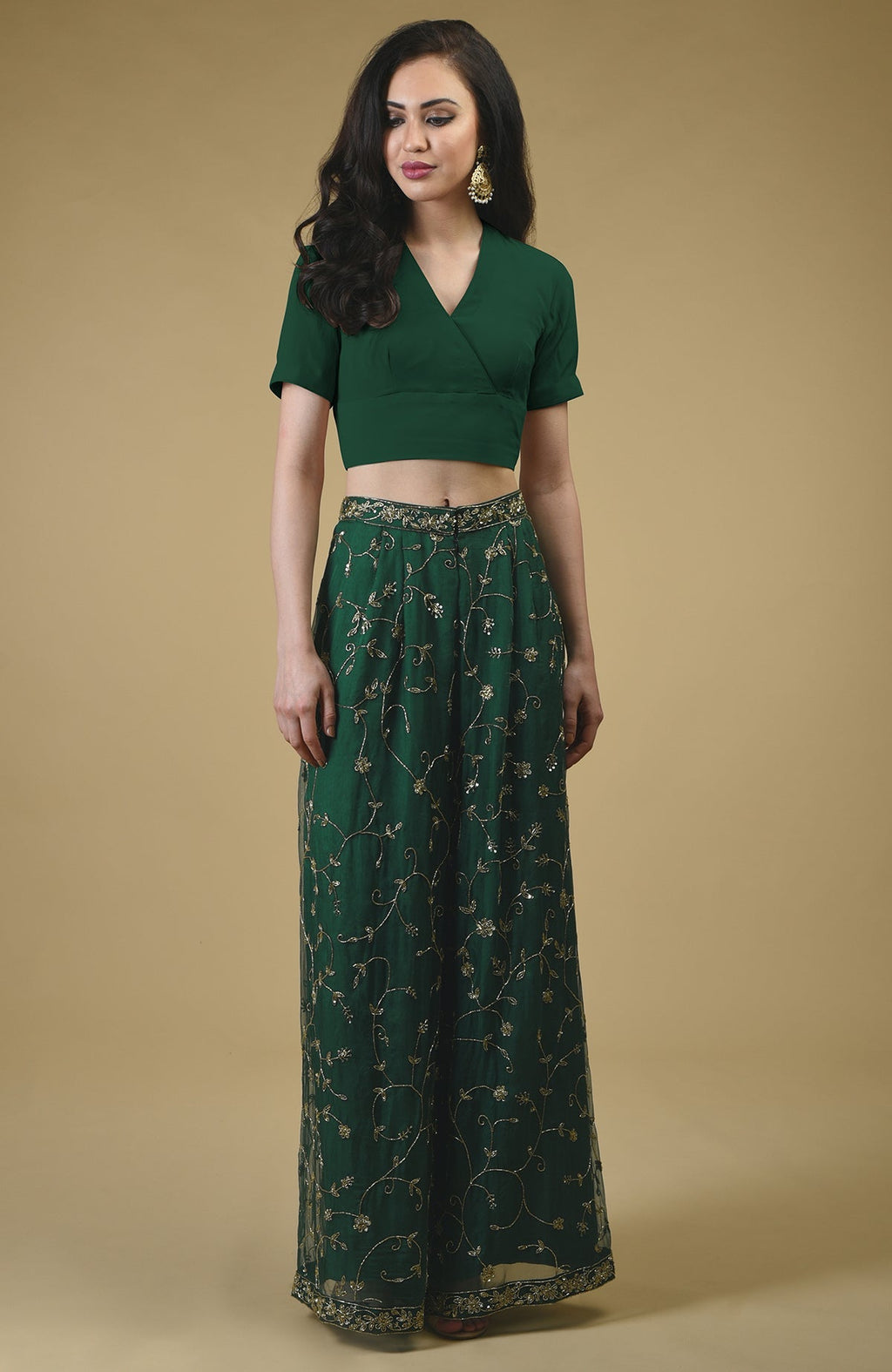 An emerald green sharara suit with gold zardozi hand embroidery.