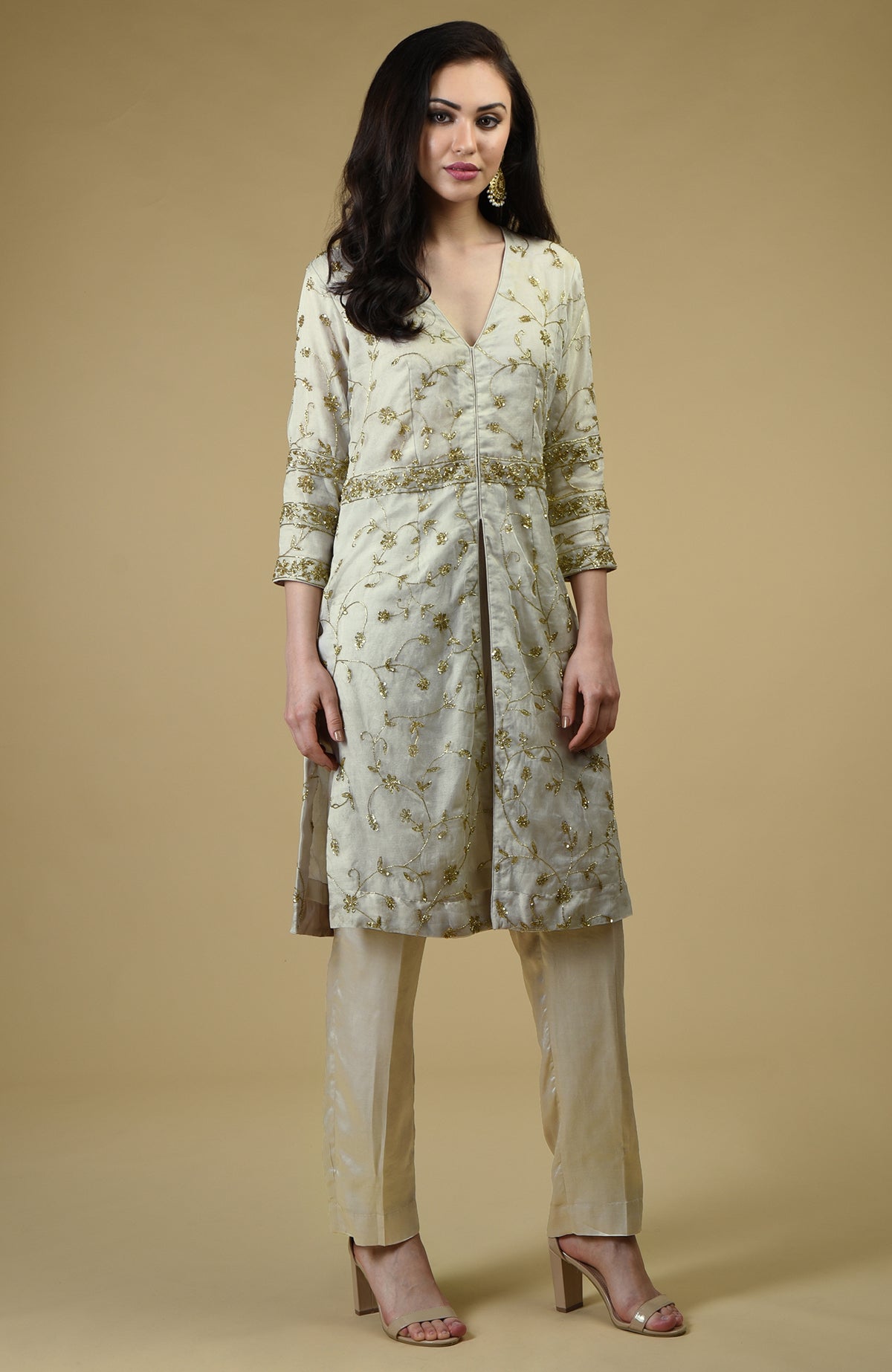 A woman models a star white beads zardozi hand embroidered tunic set.