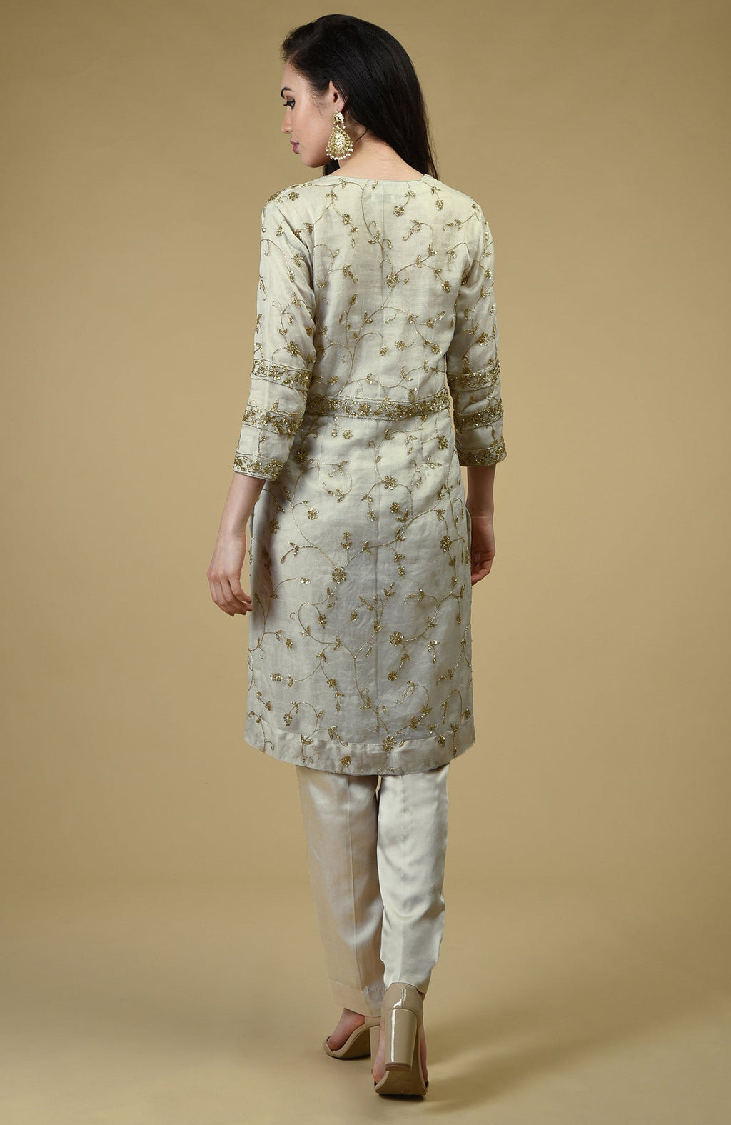 A woman from behind wears a star white beads zardozi hand embroidered tunic set.