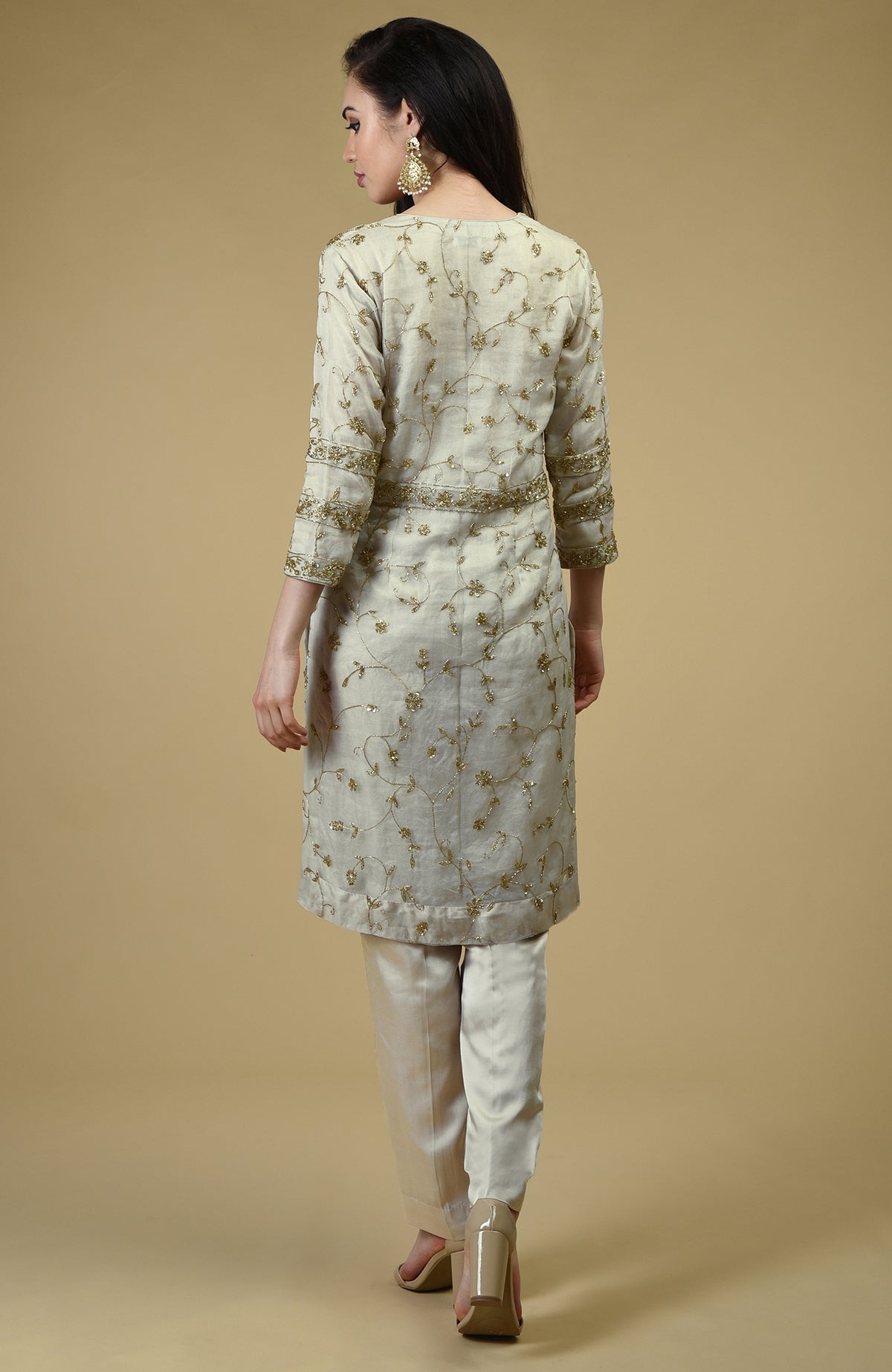 A woman from behind wears a star white beads zardozi hand embroidered tunic set.