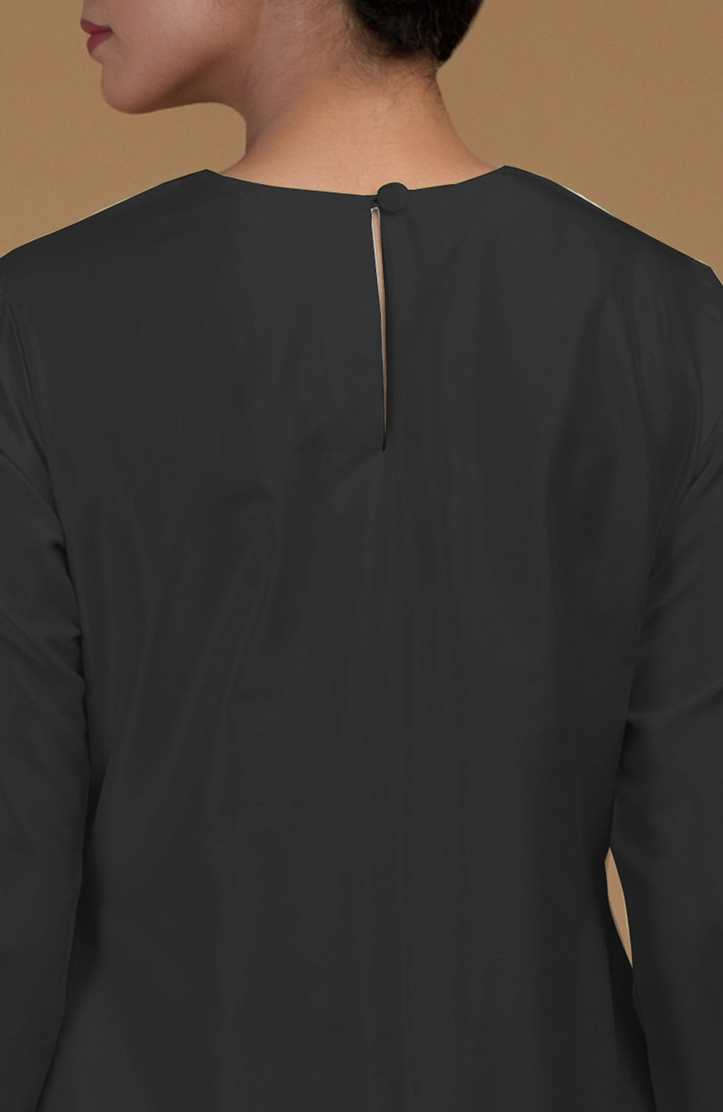A woman from the back wearing a black kurta with a keyhole back opening.