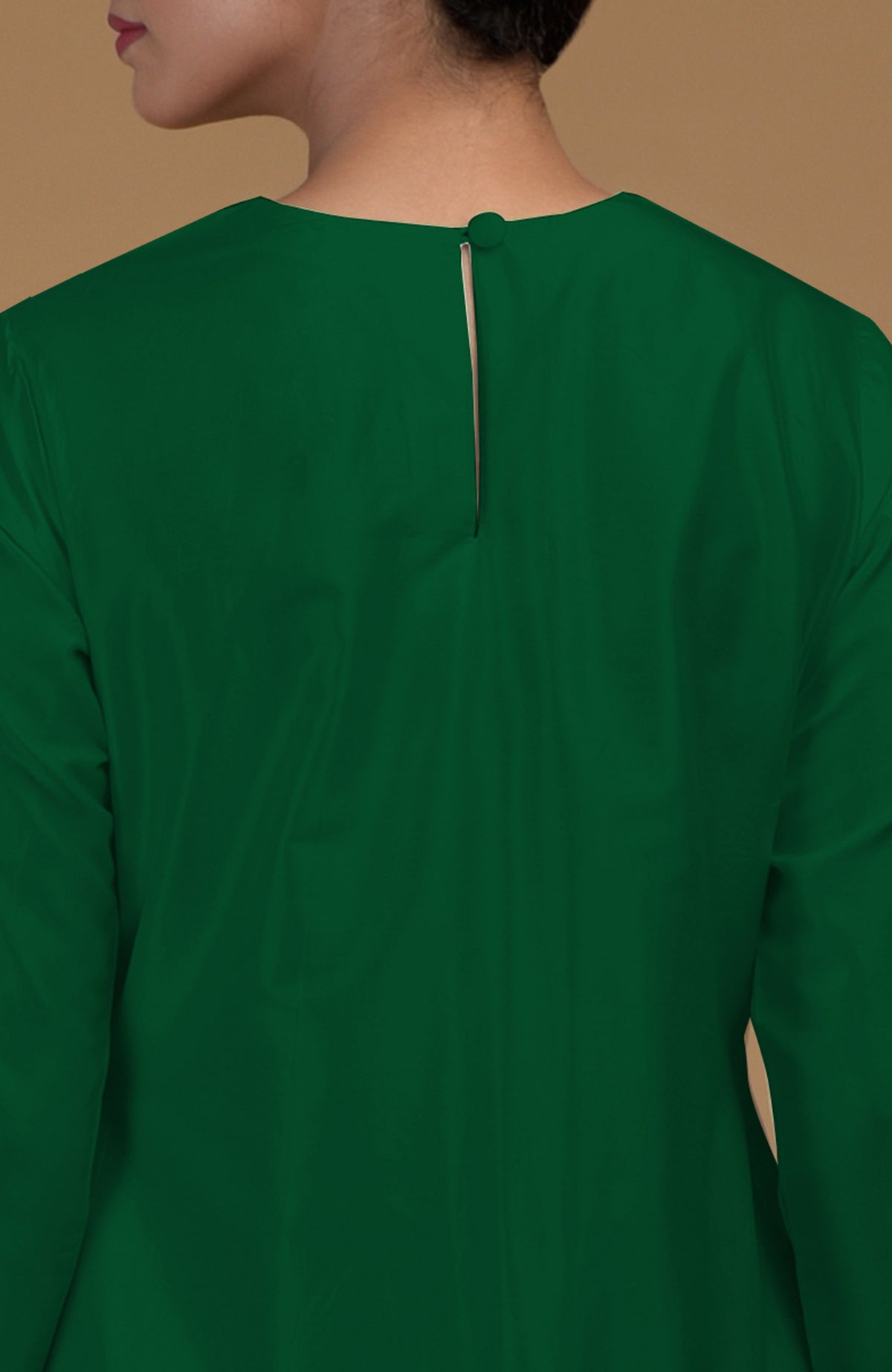 A woman from the back wearing an emerald green kurta with a keyhole back and button closure.