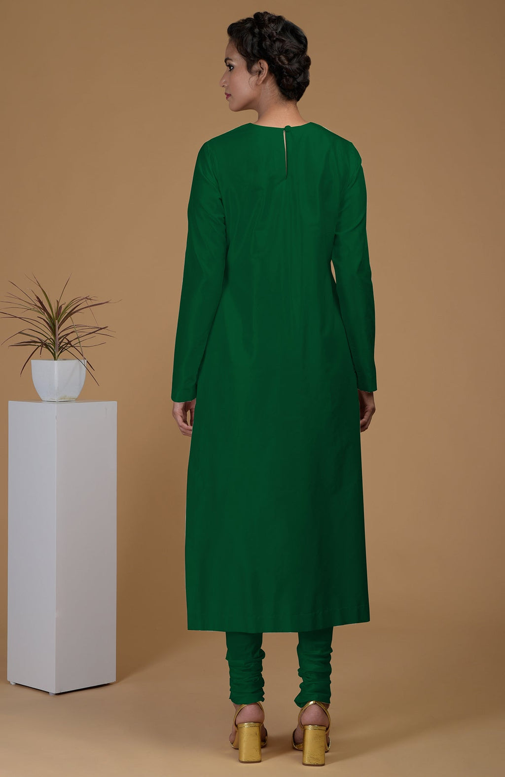 A woman from behind wears an emerald green kurta set with a keyhole back.
