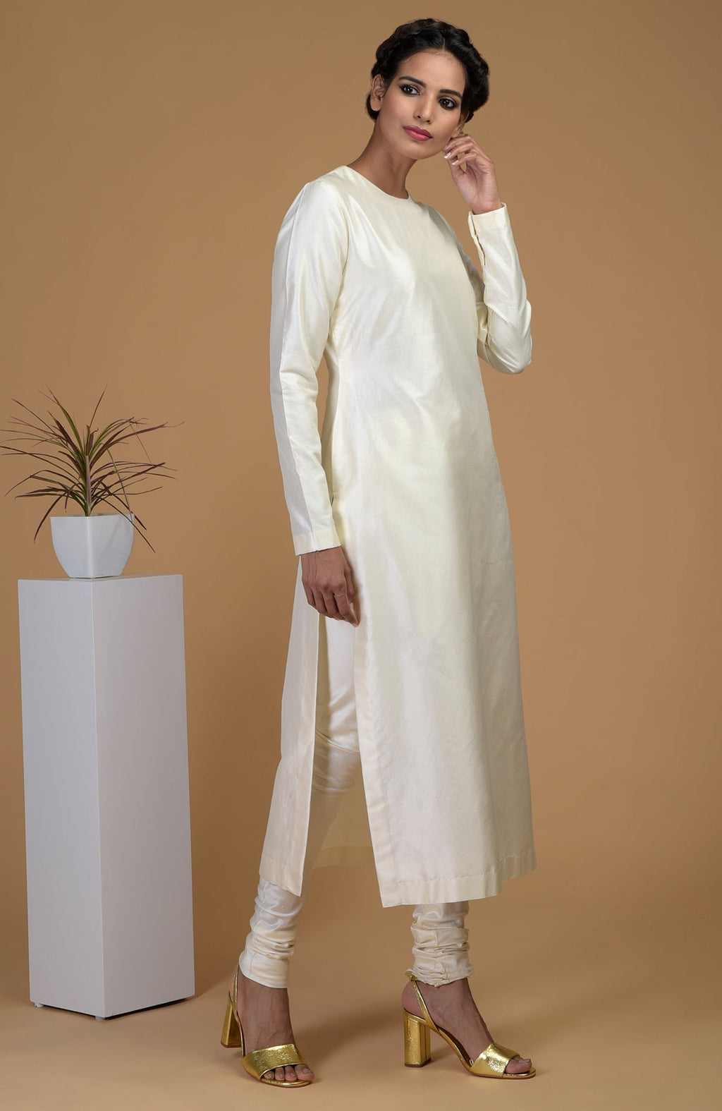 An Indian woman models an ivory pure Matka silk kurta set with churidars.