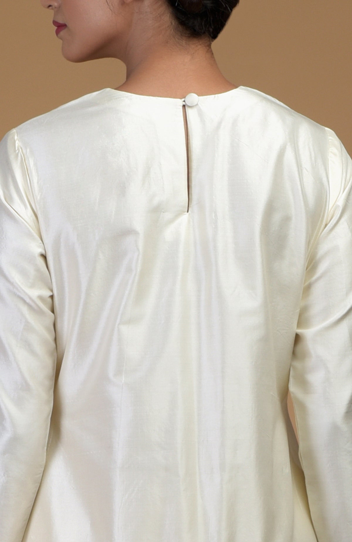A woman from the back wearing an ivory pure Matka silk kurta with a keyhole back.