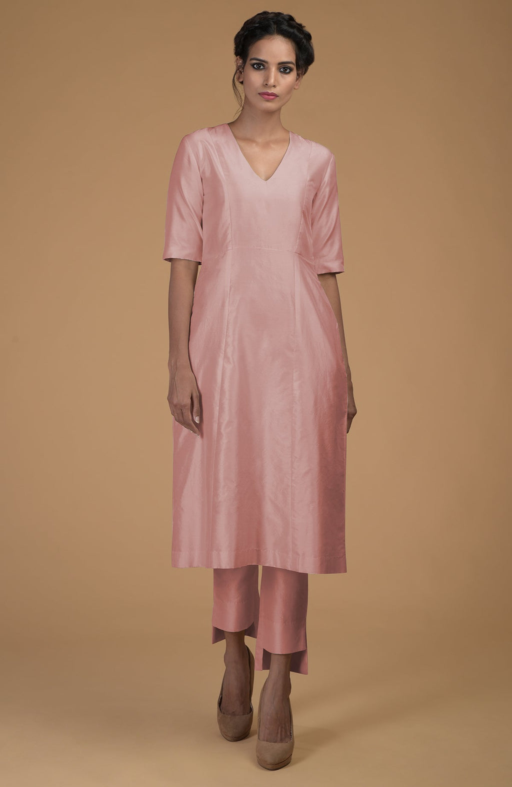 A woman models a rose beige pure Matka silk V-neck kali kurta set.