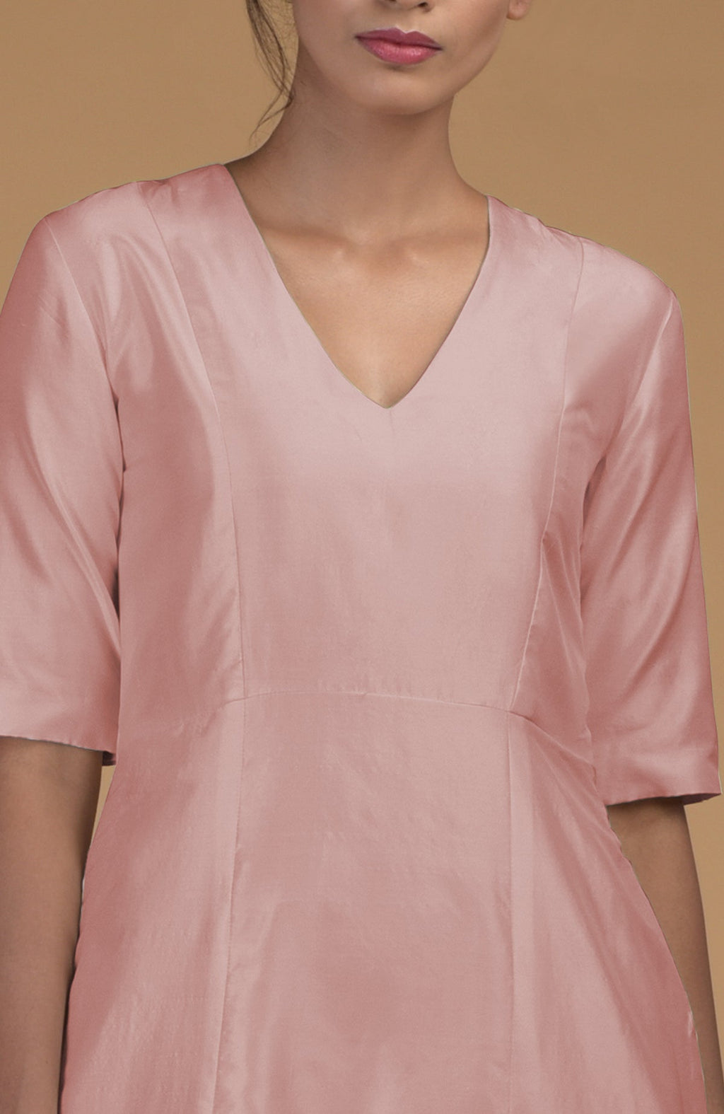 A woman models a rose beige pure Matka silk V-neck kali kurta with half sleeves.