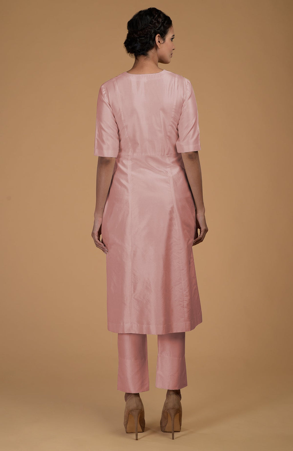 A woman from behind wears a rose beige pure Matka silk V-neck kurta set.