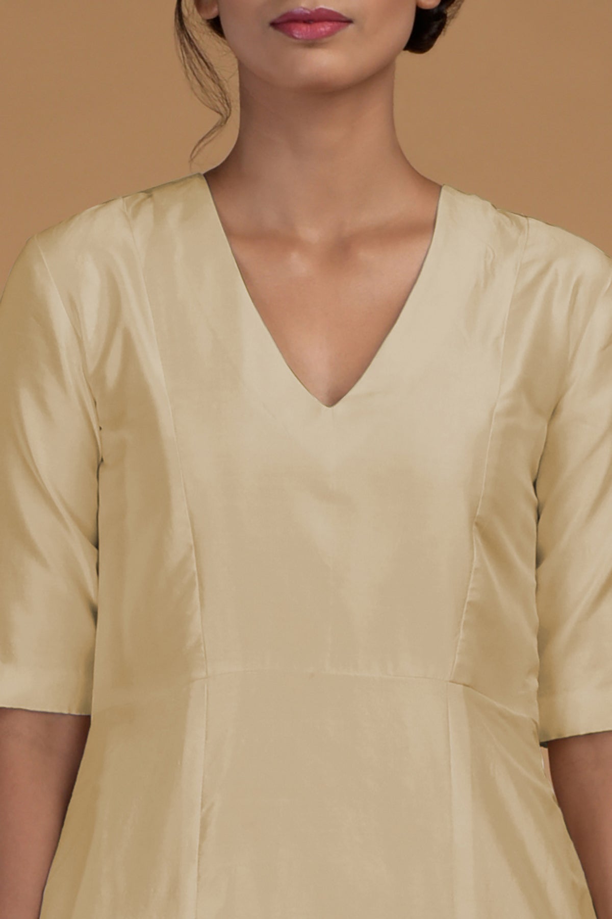 A woman wears a beige pure Matka silk V-neck kali kurta.