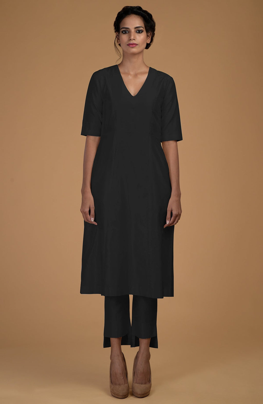 A woman models a black pure Matka silk V-neck kali kurta set with slim pants.