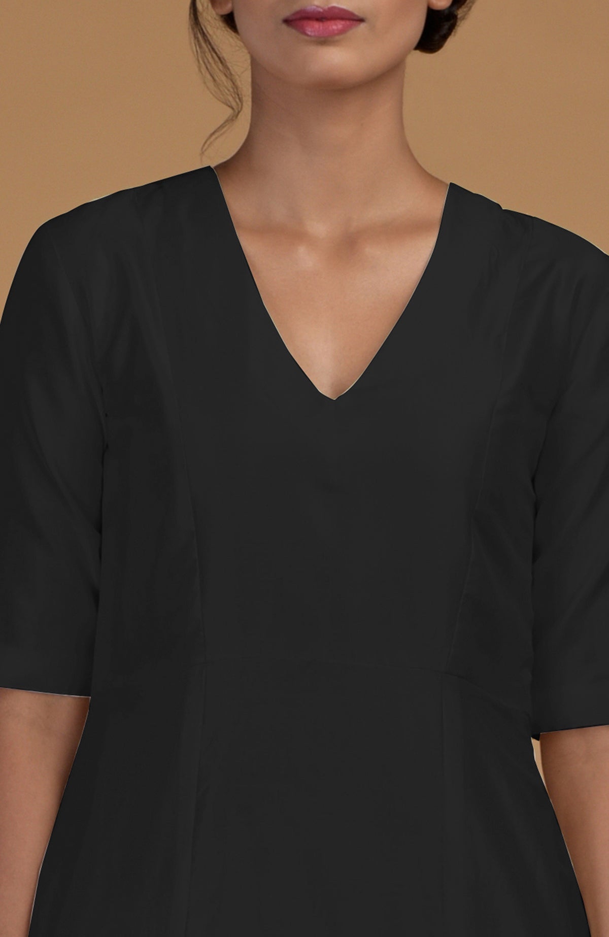 A woman wears a black V-neck kurta with half sleeves.