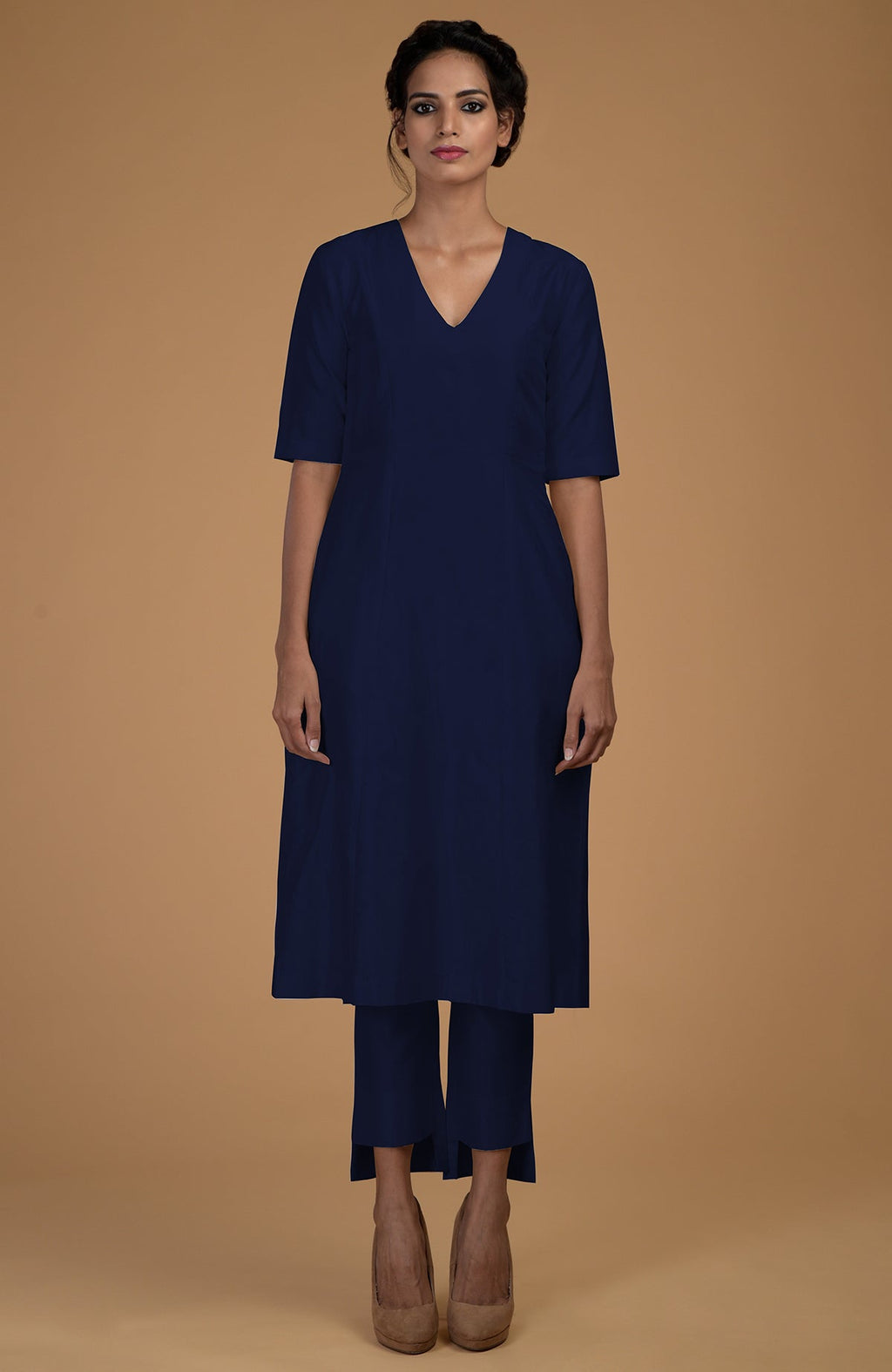 A woman models a navy blue V-neck kali kurta set with slim-fit pants.