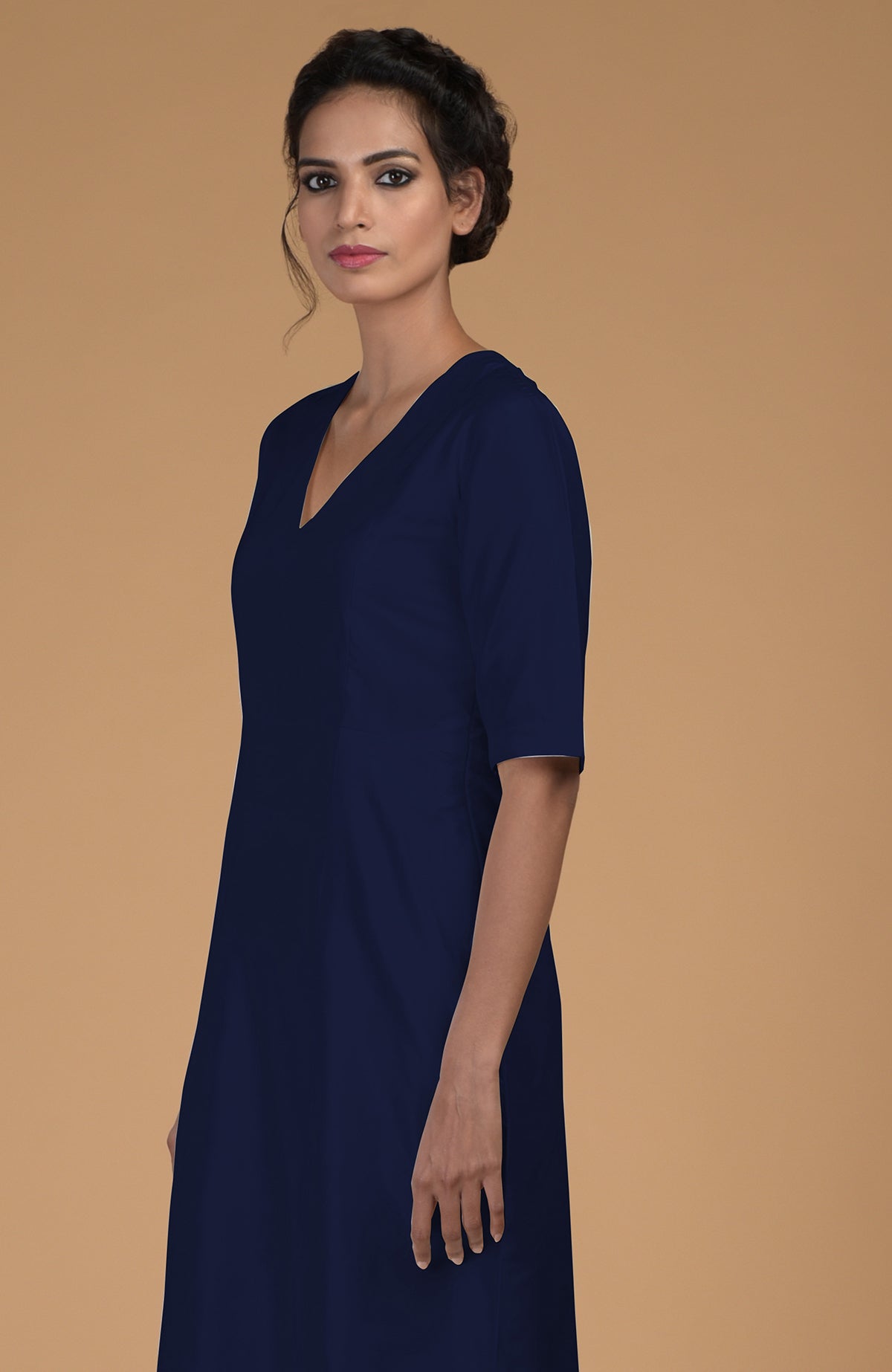 A woman models a navy blue pure Matka silk V-neck kali kurta.
