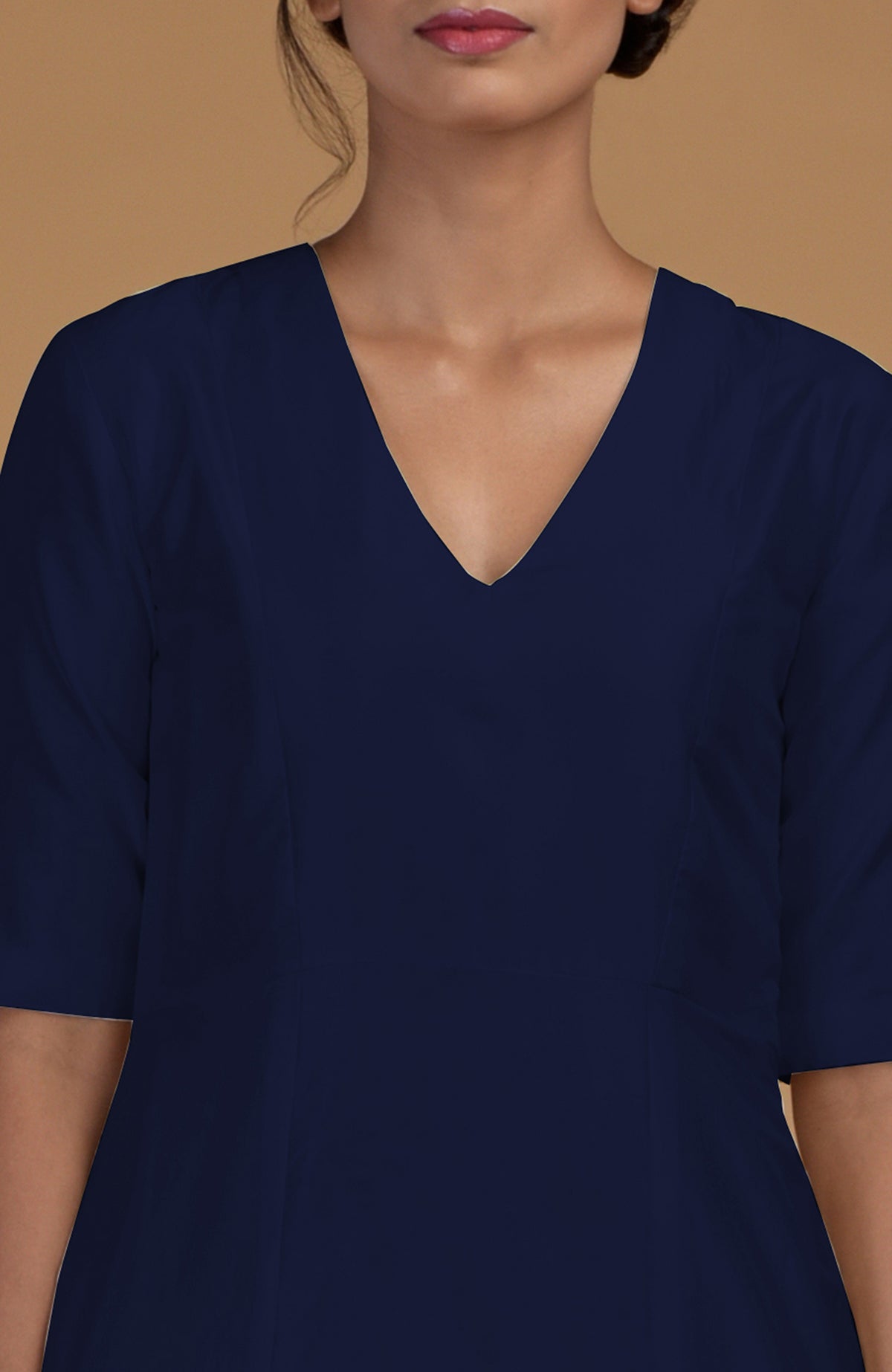A woman models a navy blue V-neck kali kurta with half sleeves.