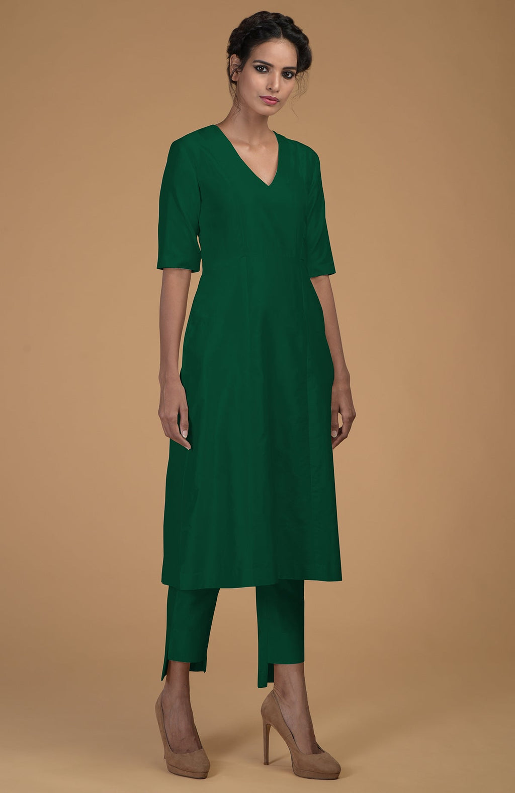 An emerald green Matka silk V-neck kurta and slim pants set.