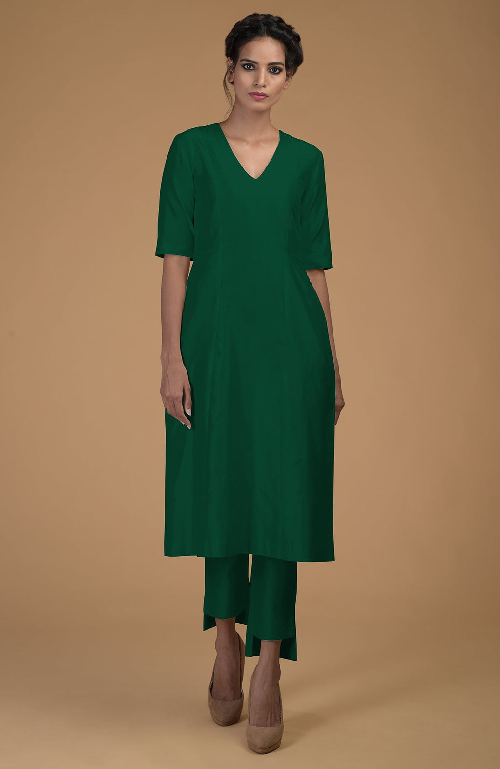 An Indian woman models an emerald green pure Matka silk V-neck kali kurta set.