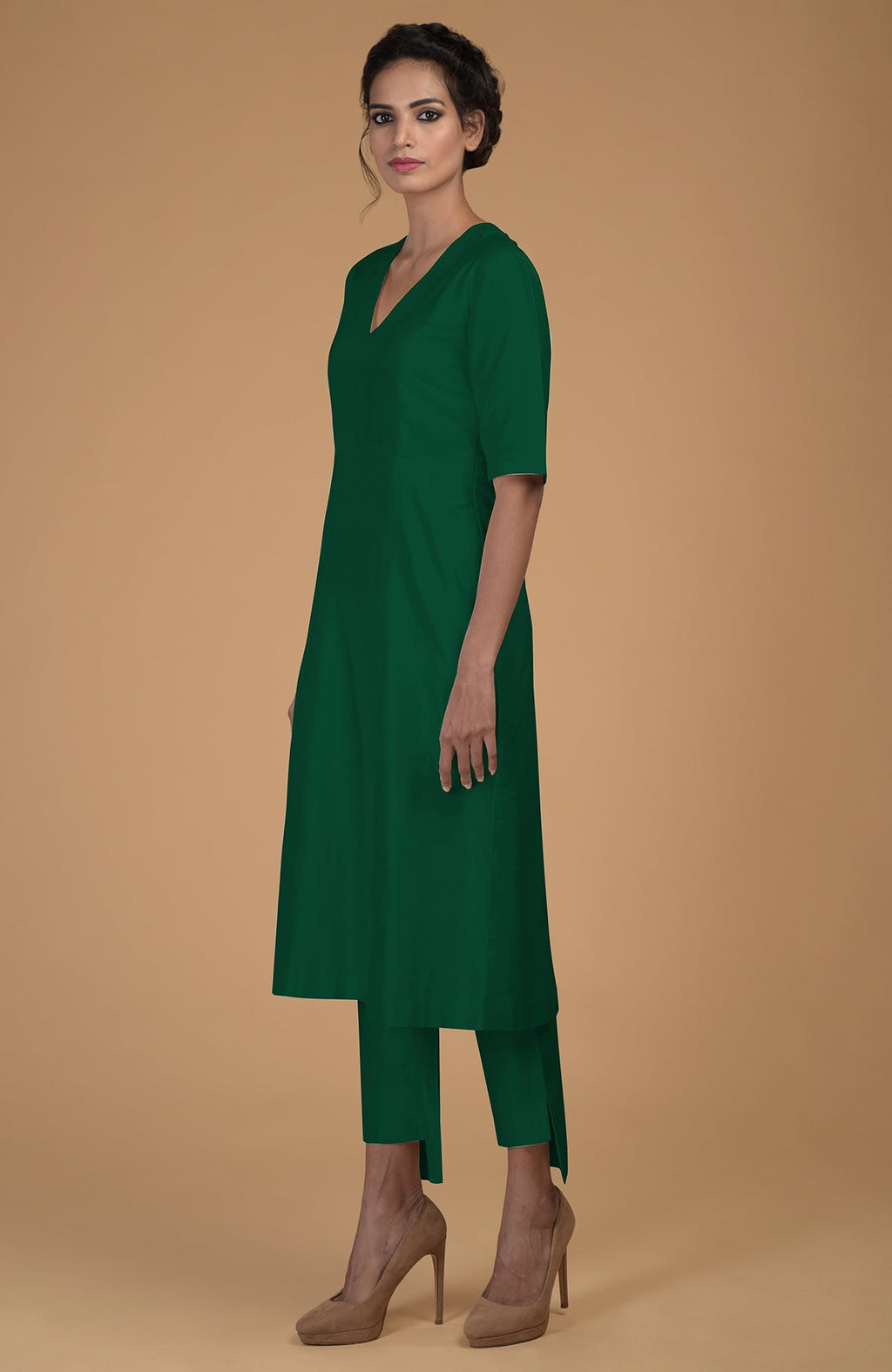 An emerald green pure Matka silk V-neck kali kurta set is shown on a model.