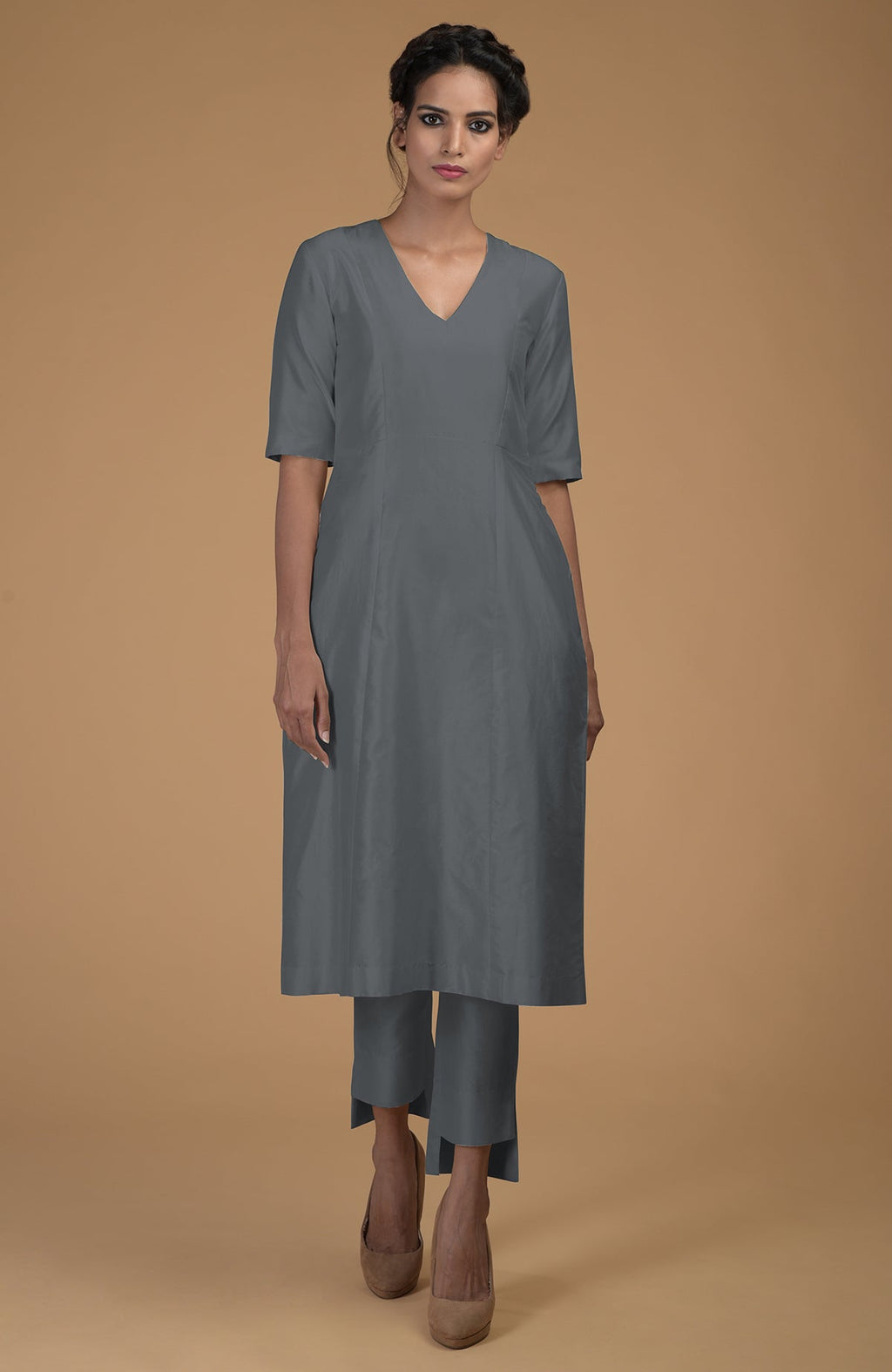 A woman models a grey Matka silk V-neck kali kurta set with slim pants.