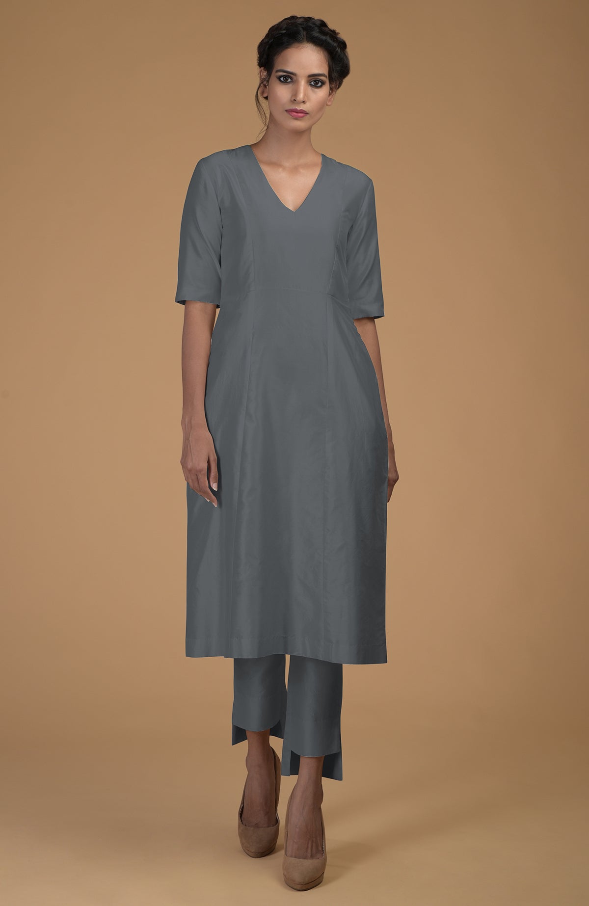 A woman models a grey Matka silk V-neck kali kurta set with slim pants.