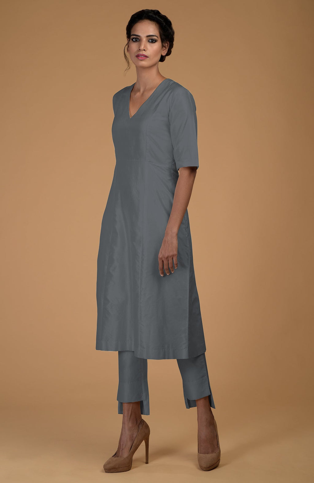 A woman models a grey pure Matka silk V-neck kali kurta set with slim pants.