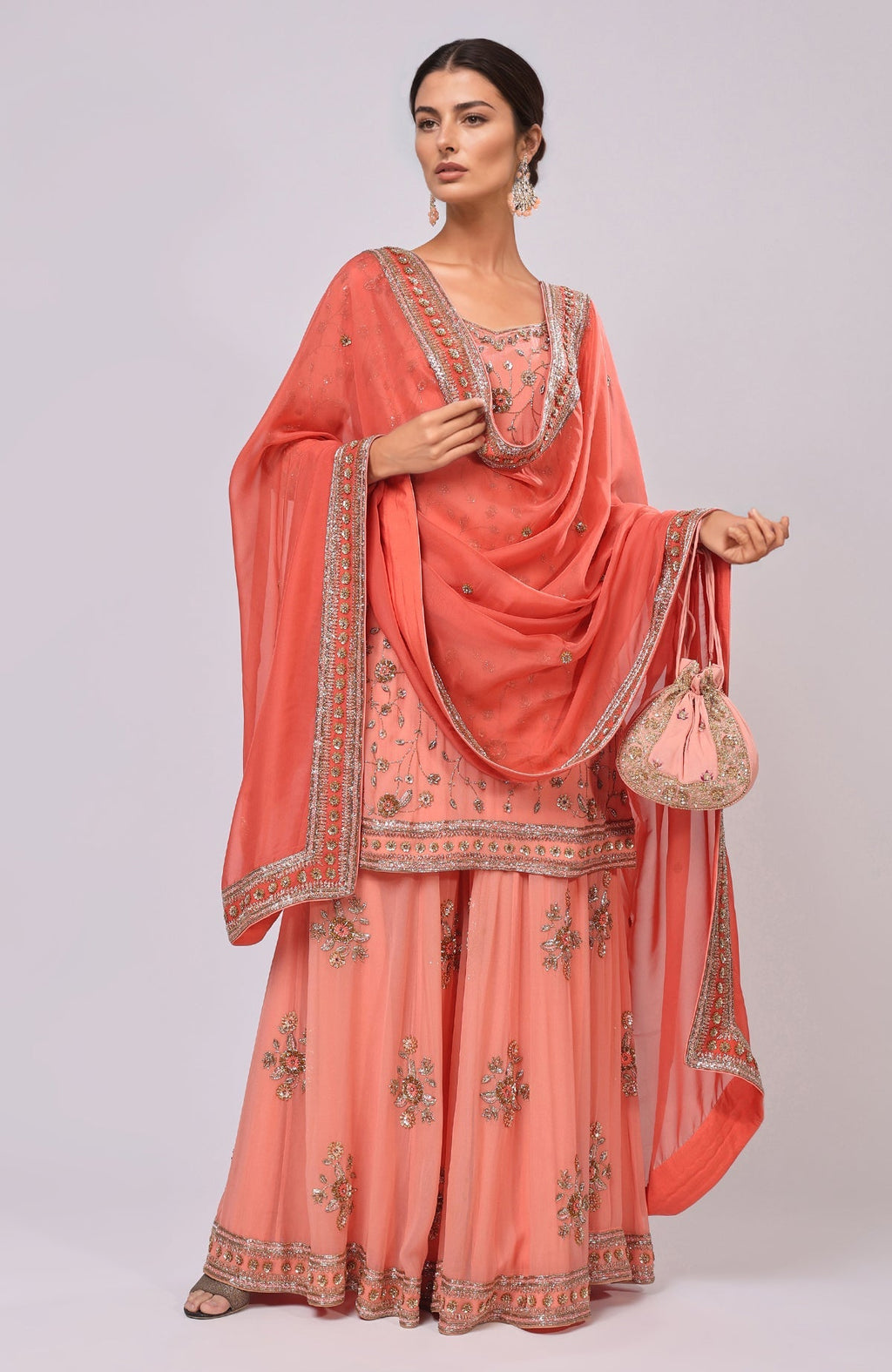 A model wears a salmon dabka and zardozi hand-embroidered sharara set.