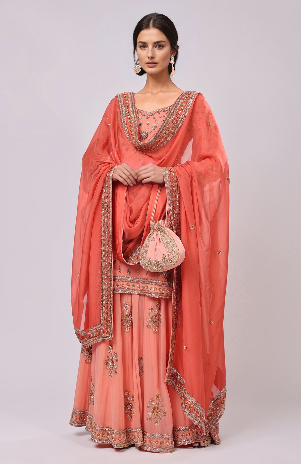 A woman models a salmon dabka and zardozi hand-embroidered sharara set.
