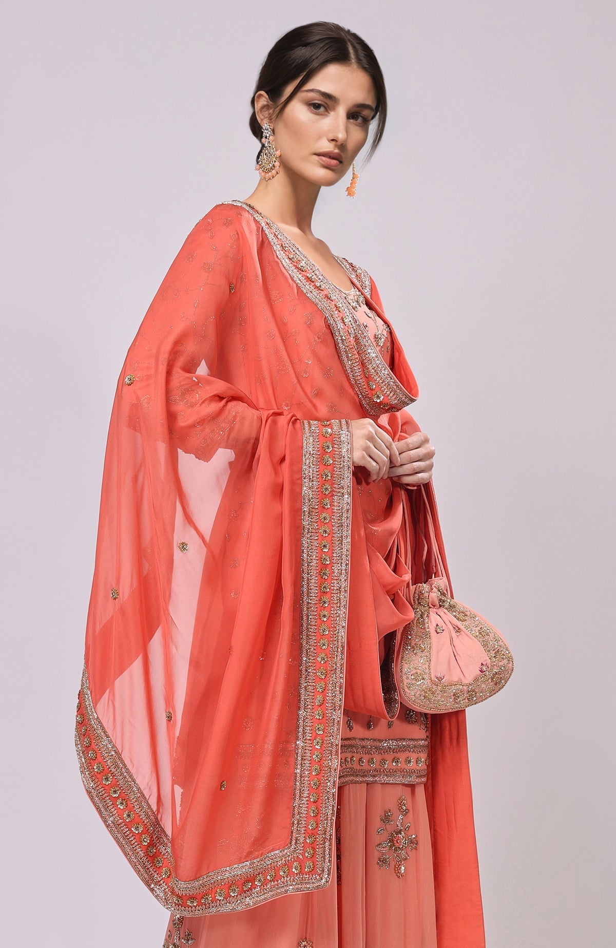 A woman models a salmon dabka and zardozi hand-embroidered sharara set.
