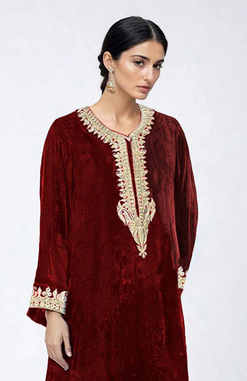 Maroon velvet pheran kurta with gold Kashmiri tilla dozi embroidery on the neckline and sleeves.
