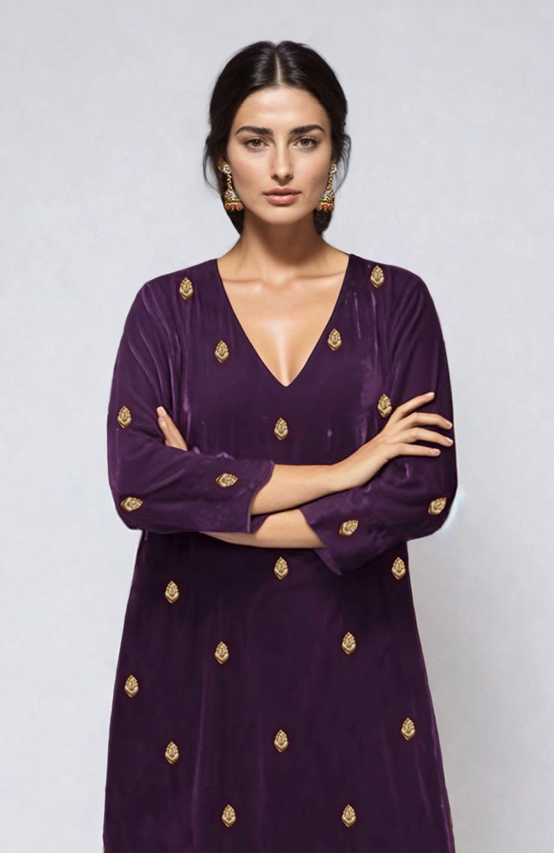 A woman models a plum velvet kurta with gold dabka zardozi embroidery.