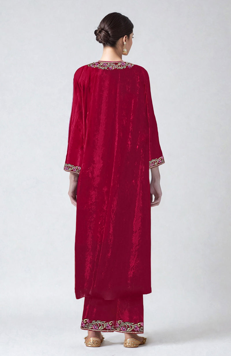 A model from behind wears a ruby red velvet kurta set with intricate embroidery.
