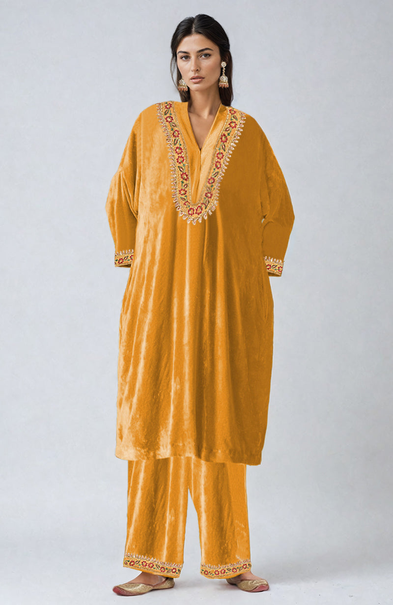 Mustard velvet kurta set with intricate floral embroidery on the neckline, sleeves, and pants.