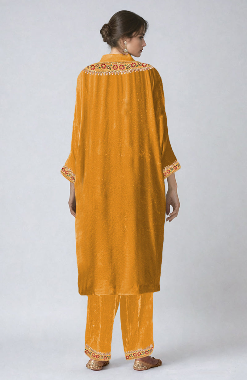 Mustard velvet kurta set with colorful floral embroidery on the neckline, sleeves, and pants.