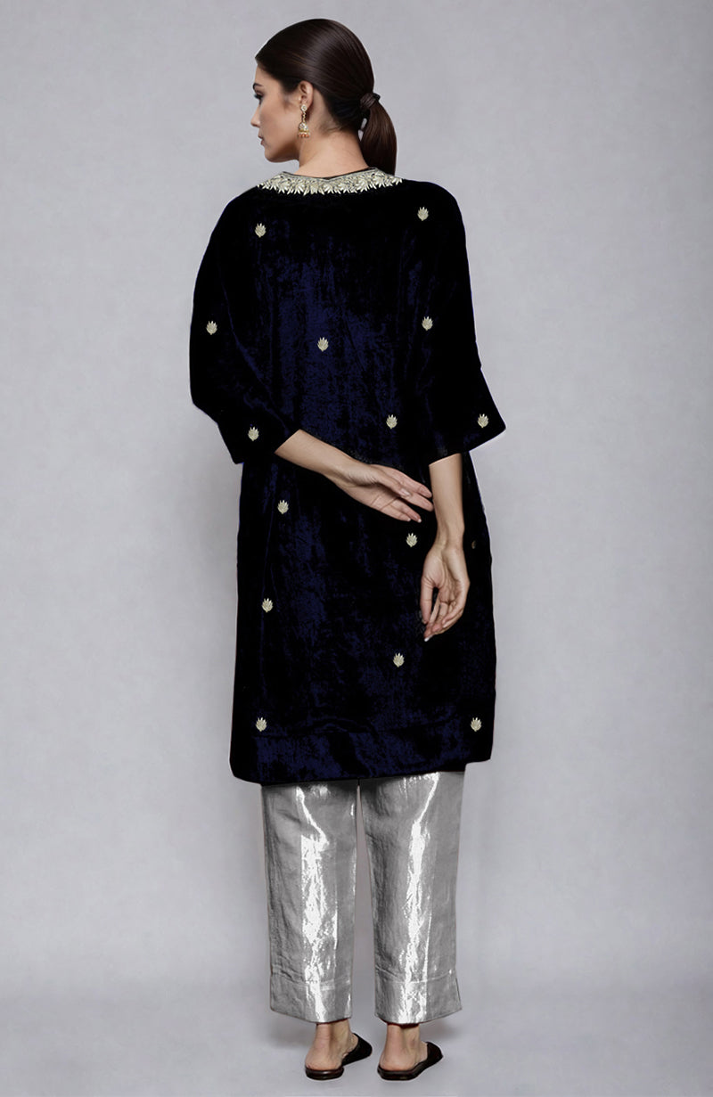 A woman models a midnight blue velvet kurta with silver embroidery and silver tissue pants.