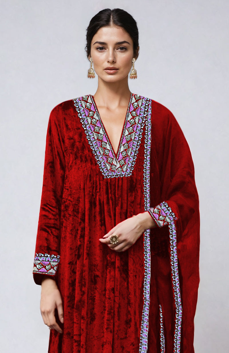 A woman models a red velvet kurta with colorful embroidery on the neckline and sleeves.