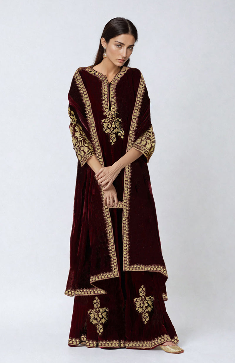 A model wears an Emerald Green Velvet Kashmiri Tilla Embroidered Sharara set.