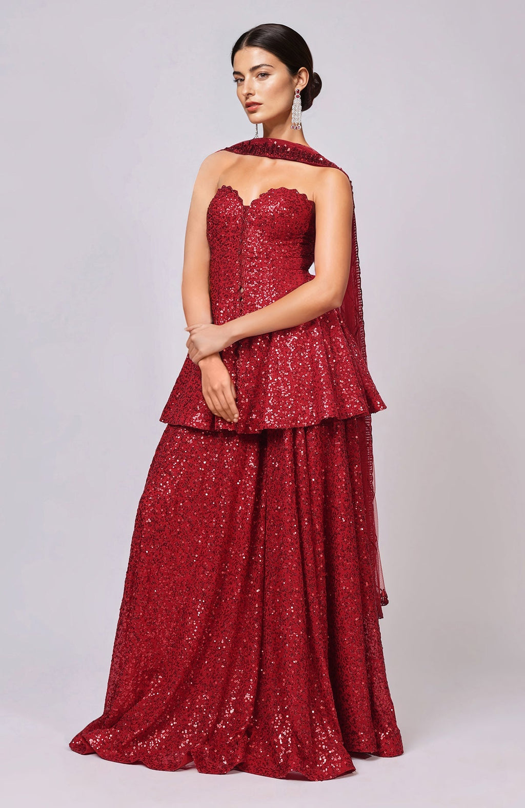 Red sequined peplum top with sweetheart neckline and flared sharara pants with embellished dupatta.