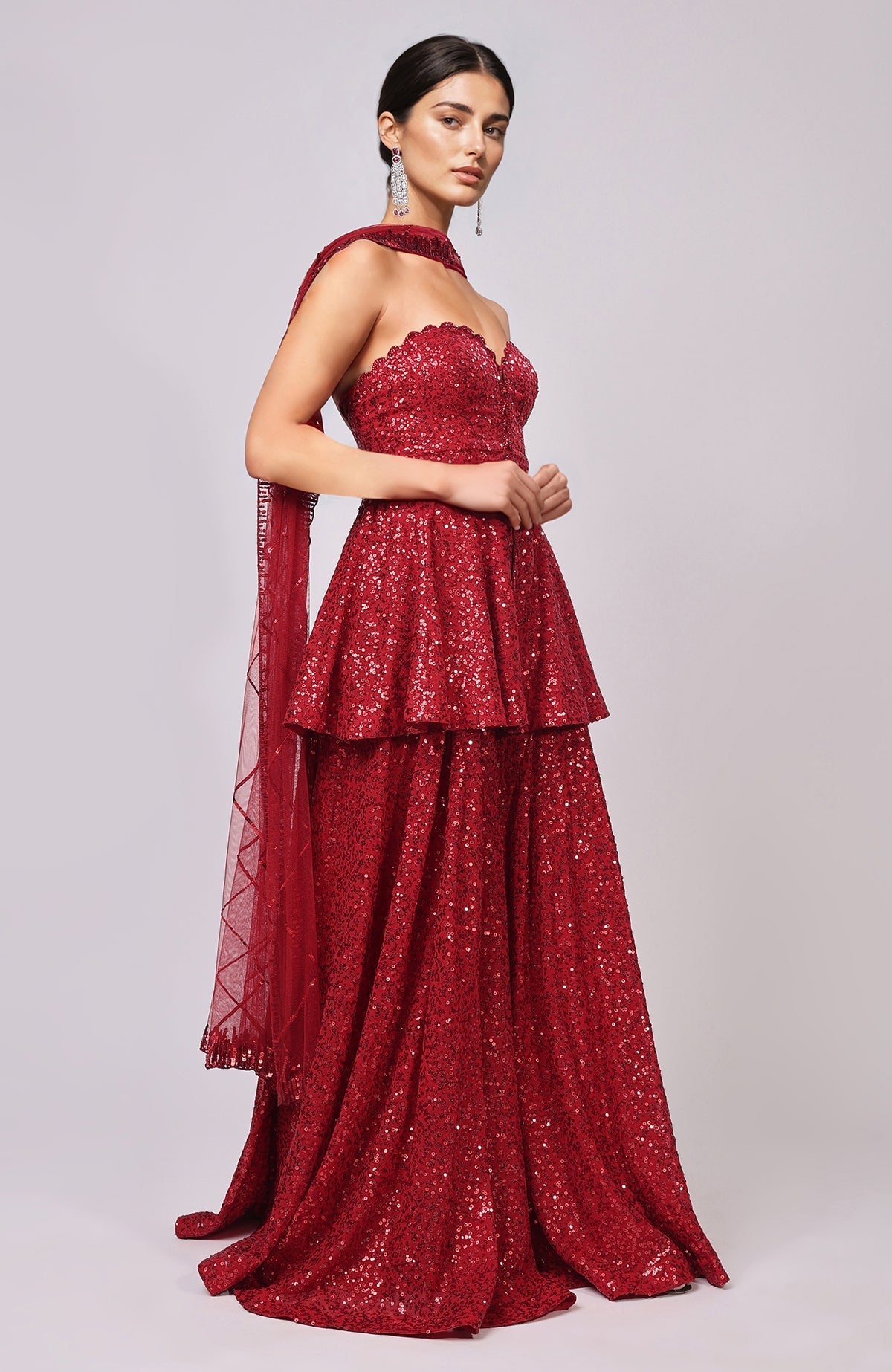 Red sequin embroidered sharara set with a peplum top and embellished dupatta.