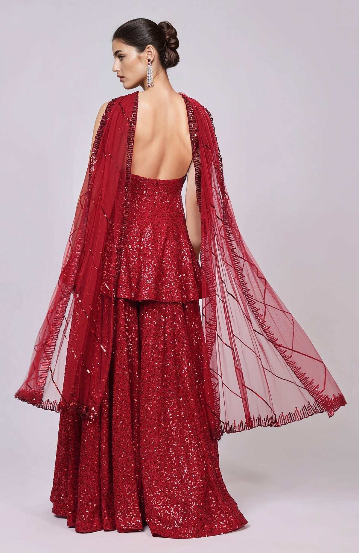 Red sequined peplum top with sweetheart neckline, flared sharara pants, and embellished dupatta.
