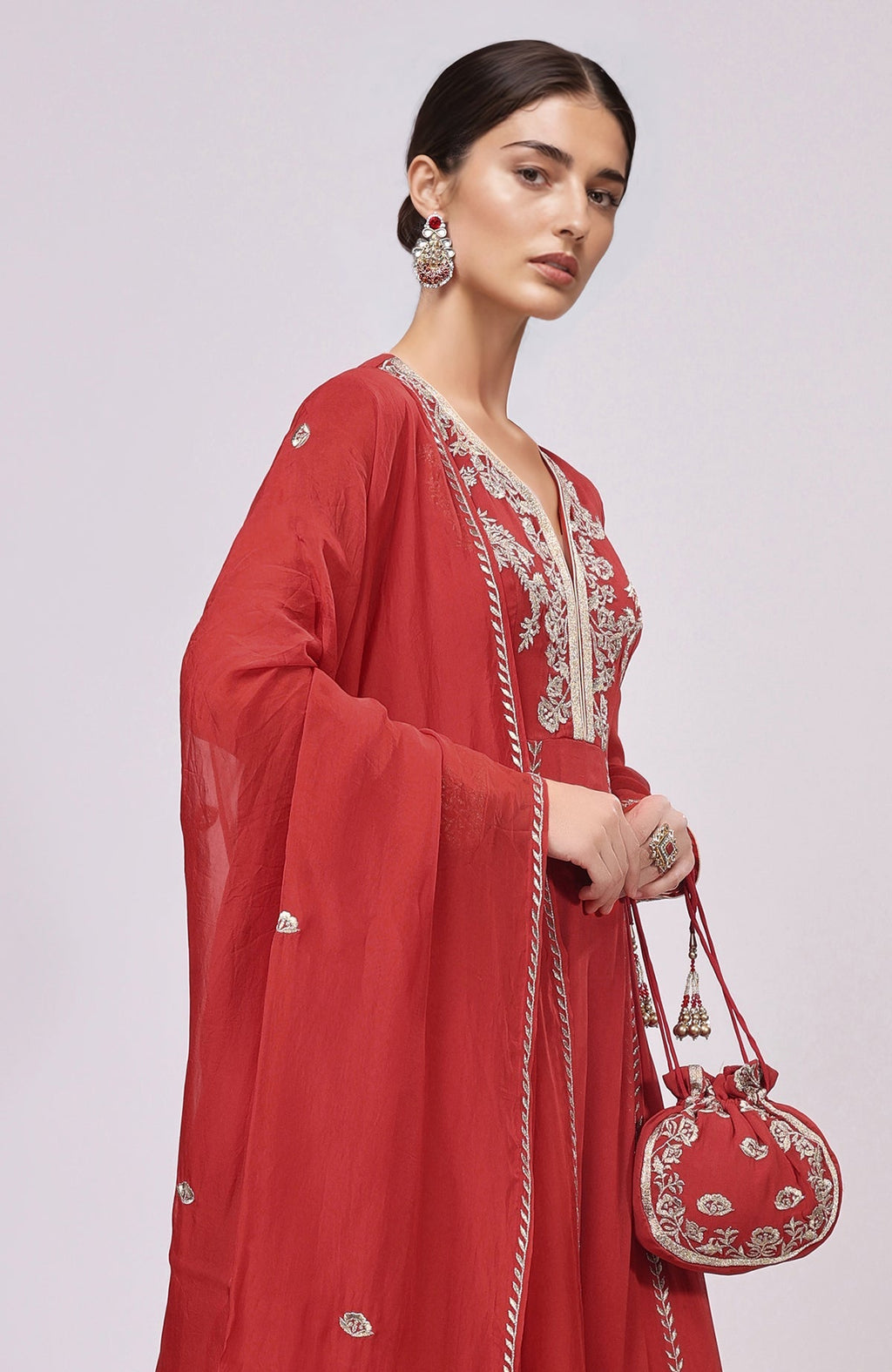Red Anarkali set with Kashmiri Tilla Aari embroidery on kurta, dupatta, and potli bag.